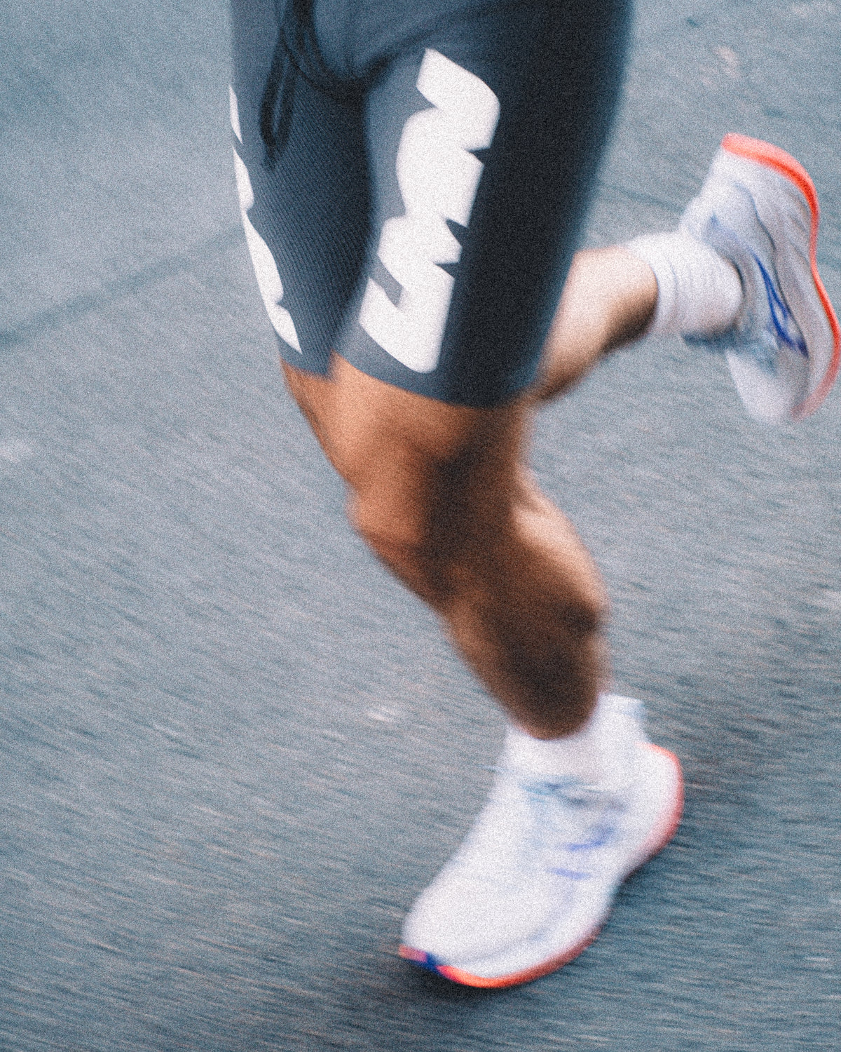 Runner in motion wearing LUMEN shorts and white running shoes